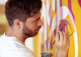 To Infinity and Beyond A man, carefully paining onto a wall