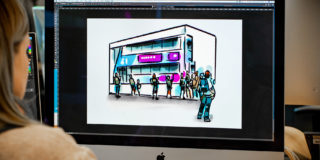 woman looking at Bus in a Box Scamp on desktop computer