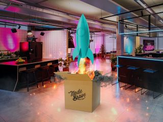 teal rocket blasting out of a cardboard box