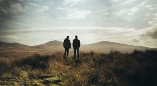 Two people standing on a hill