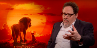 Virtual Production & The Lion King Jon Favreau sitting in front of a graphic of The Lion King