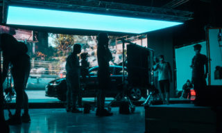 Virtual Production | Behind the Scenes photo of two people on virtual production stage with lots of neon lights adjusting equipment