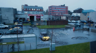 The Aftermath burning car in a parking lot