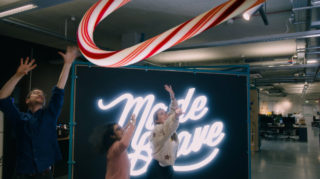 Giant Candy Cane three people jumping up and down trying to grab a giant candy cane