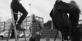 Behind the Scenes - Water Dump in 3... 2... 1... man on a ladder about to dump a bucket of water on another man