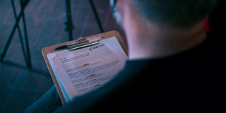 Behind the Scenes - Script photo over the shoulder of man holding the script