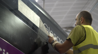 man applying sticker for New Buses Assembly