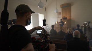 man shoots with camera as eulogy is given