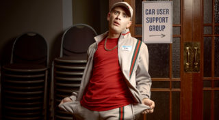 closeup photo of character, Gav, who is a young man wearing a hat, gold chain, and tracksuit