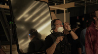 behind the scenes - Man with headphone and mask working with cameras behind the scenes