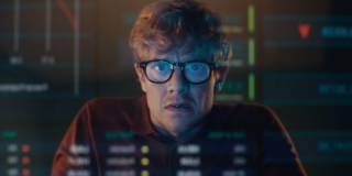 Man with glasses looking at computer screen