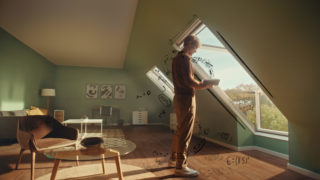 man standing at a window reading a book