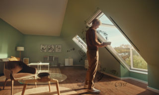 man standing at a window reading a book