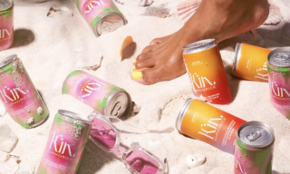 Kin euphorics cans on beach Lady on beach surrounded by kin euphorics cans