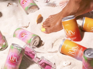 Kin euphorics cans on beach Lady on beach surrounded by kin euphorics cans