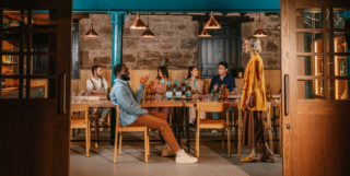 several people sitting down at a table sampling the singleton whisky and cocktails