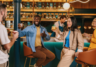 several people standing at the singleton bar smiling and having cocktails
