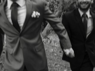 two men holing hands wearing suits representing LGBTQ+ families