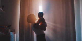 silhouette of a woman holding a baby in front of a window