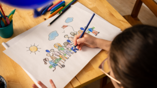 photo of a child colouring a picture of people doing the blue balloon challenge