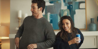 A super bowl commercial still of a man and woman dancing holding cans of bud light