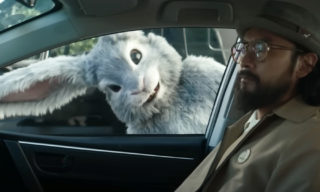 Tubi - Rabbit Hole A super bowl commercial still of a bunny peering in through the passenger side window of a car at a man with a dark beard, glasses, and hat