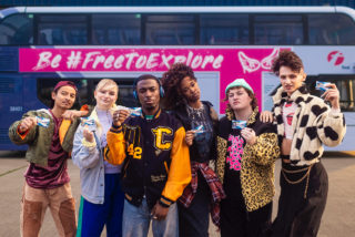 U22's standing in front of a First Bus and showing their NEC cards.
