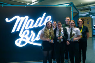 photo of several people standing in front of the white MadeBrave sign