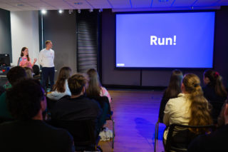 a photo of emma and ben Presenting the New Sprun Brand with a blue slide up that says 