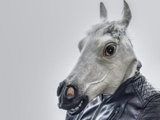 photo of a man wearing a horse mask and a leather jacket