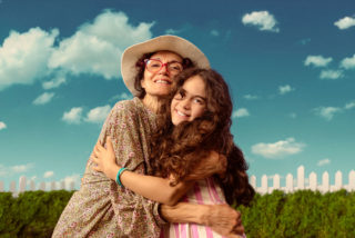 a photo of an older woman with red glasses hugging a young woman with brown hair
