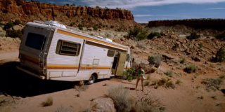 still frame of a scene from the show breaking bad. An RV has run into a ditch in the desert with a man standing in his underwear looking at it