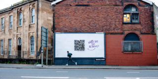 Catherine McEwan Foundation x MadeBrave - A Sh*t Campaign a man walking past a billboard with a QR code made of toilet roll