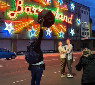 behind the scenes photo of a couple outside of the neon barrowland sign