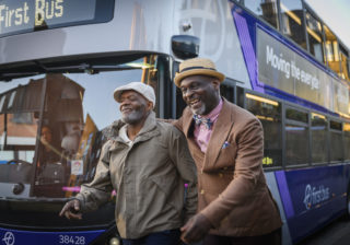 Two men walking down the street and smiling