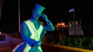 a photo of a statue of the johnnie walker with a st andrews cross skin