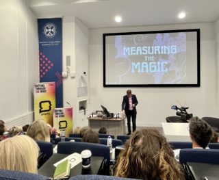 The Marketing Society Amplify Festival a photo of Orlando Wood, CIO at System One showing a slide that says 'measuring the magic'