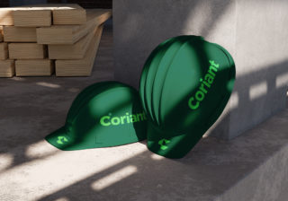 Coriant Branding photo of two forest green hardhats sitting on a construction floor with the coriant logo running along the side