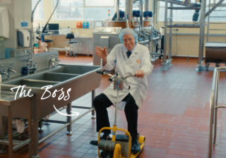 Tunnock's Brand Film - Tunnock's Owner, Sir Boyd Tunnock photo of Tunnock's owner, Sir Boyd Tunnock, waving and riding a scooter through the Tunnock's factory