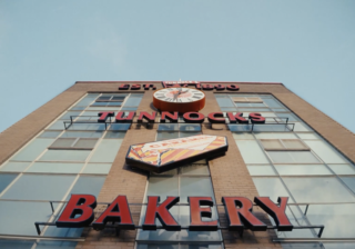 Tunnock's Brand Film - Outside the Tunnock's Factory a photo looking up at the tunnock's factory building entrance. The sign above says Tunnock's Bakery in red